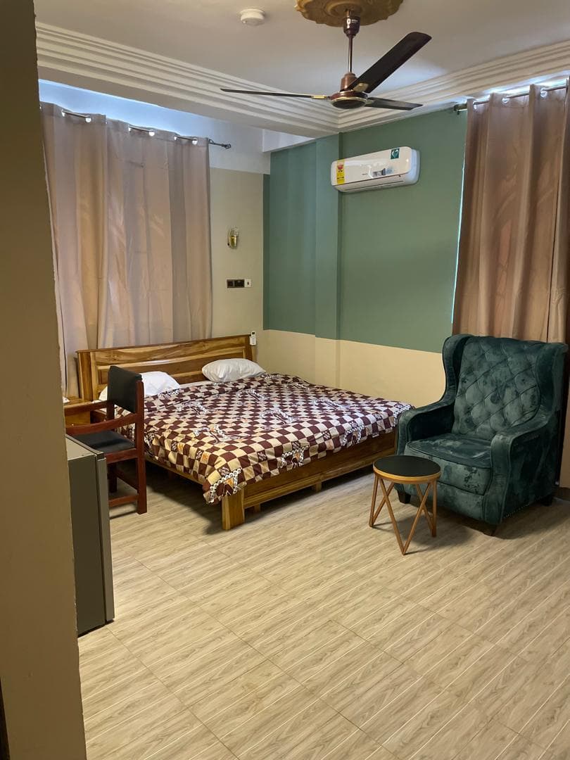 Deluxe room at Equal Hotel with queen bed and sofa seating area